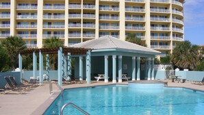 A swimming pool with lounge chairs and a covered pavilion, surrounded by a multi-story building with balconies. - ShellChase | 5BR/3.5BA Martinique Home | Sleeps 12 | Gulf Views + Pool (GULF SHORES)