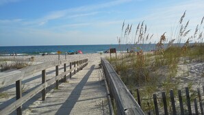 A wooden boardwalk leading to a sandy beach with a clear view of the ocean. - ShellChase | 5BR/3.5BA Martinique Home | Sleeps 12 | Gulf Views + Pool (GULF SHORES)