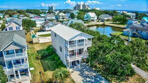 A residential area with houses, a body of water, and a clear sky.