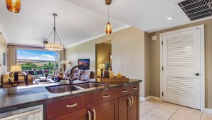 A modern kitchen with a large island, stainless steel appliances, and a view of the outdoors.