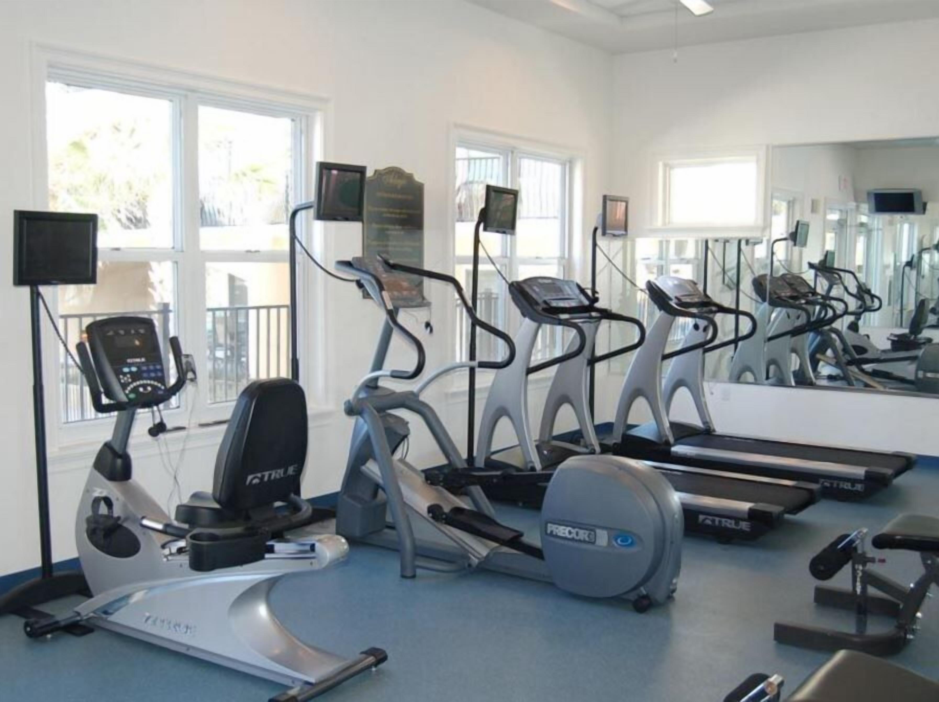 A gym with treadmills, elliptical machines, and a stationary bike.