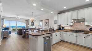 A spacious kitchen with white cabinetry, a granite countertop, and a built-in island.