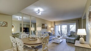 A spacious living room with a dining area, a sofa set, and a balcony with a view. - 238 Shorewood- 2nd Floor Landscape View steps to the beach. (Hilton Head Island)