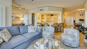 A spacious living room with a blue sofa, patterned armchairs, and a coffee table with candles. - 3 bedroom/3 bathroom 2nd floor oceanfront condo with lots of amenities (Hilton Head Island)