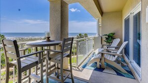 A balcony with a table and chairs, a view of the ocean, and a potted plant. - 3 bedroom/3 bathroom 2nd floor oceanfront condo with lots of amenities (Hilton Head Island)
