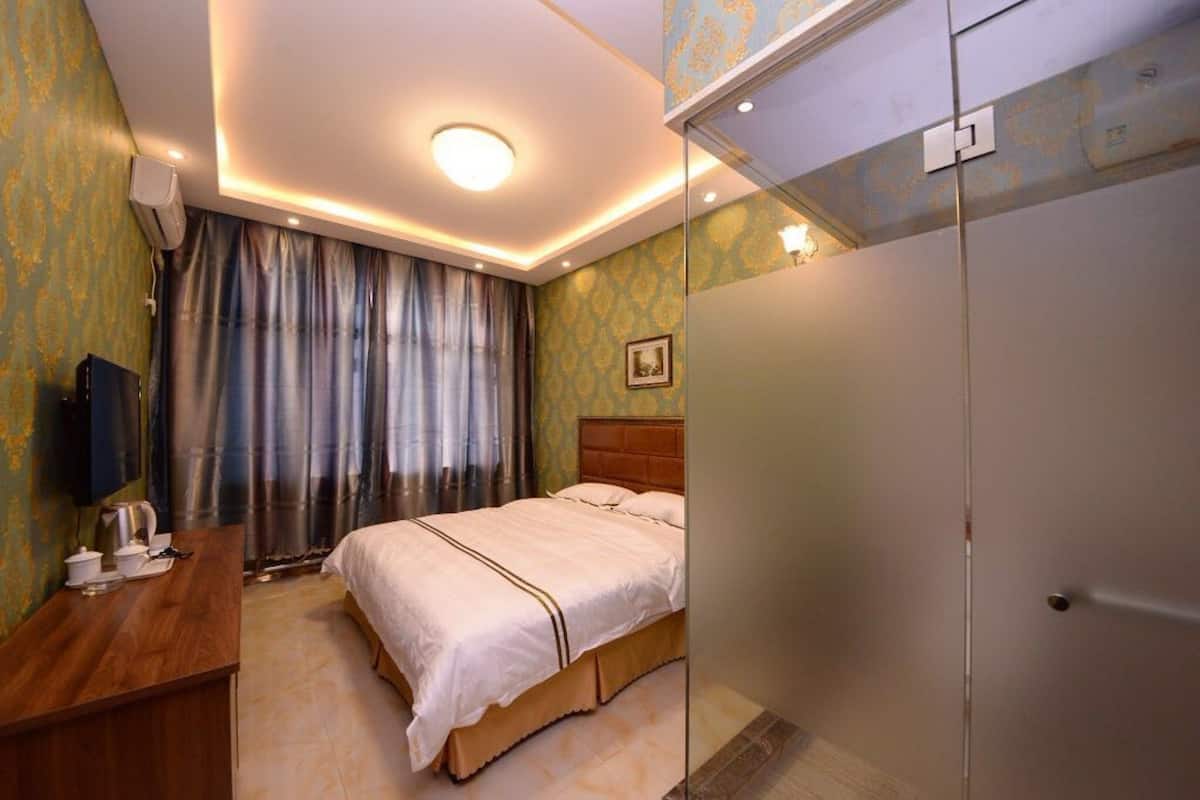 Ein Hotelzimmer mit Bett, Schreibtisch, Spiegel und Kleiderschrank.