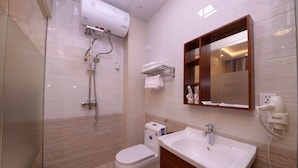 Uma casa de banho moderna com cabine de duche em vidro, sanita, lavatório e toucador com espelho.
