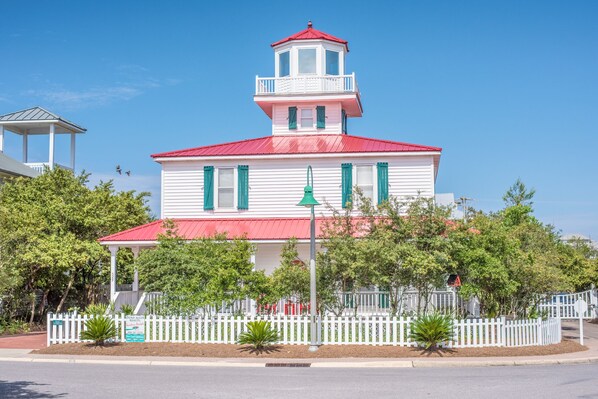 A white building with a red roof and a small tower, surrounded by a white picket fence and trees. - On Beach Side, Gated neighborhood, All King Beds, Pool, Santa Rosa beach (Santa Rosa Beach)