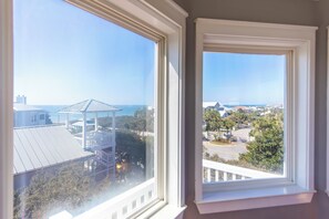 A view through a window of a building with a gazebo, a parking area, and a clear sky.