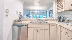 A kitchen with a dishwasher, a sink, and a coffee maker.