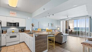 Una cocina moderna con una isla central, un comedor con vistas y un balcón panorámico.