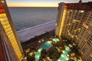 Un hotel con zona de piscina, vista a la playa y edificios altos.