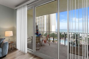 Un balcon avec vue sur un immeuble de grande hauteur et une piscine.