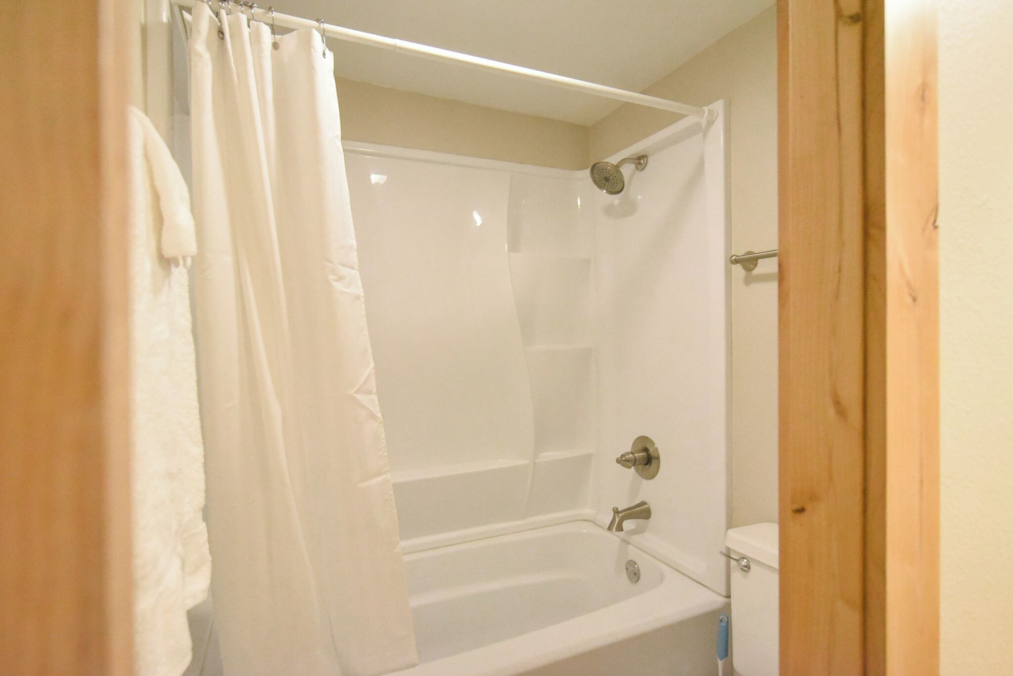 A bathroom with a bathtub, shower, and toilet.