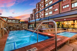 A hotel with a pool area, including a hot tub and a smaller pool.