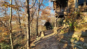 Un rustico chalet con una scala in pietra che conduce a un portico in legno.