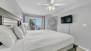 A hotel room with a large bed, a ceiling fan, a TV, and a view of the outdoors. - Gulf View View,Beach Service, Maravilla 2303! (Miramar Beach)