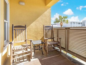 Enjoy the tranquil views from this balcony, featuring a comfortable seating area with two chairs and a table.