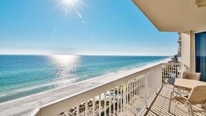 Un balcon avec vue sur une plage et l’océan.