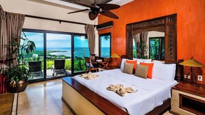 A spacious bedroom with a large bed, a ceiling fan, and a view of the ocean through floor-to-ceiling windows. - Casa Pipilacha♛Impressive Ocean view♛ Infinity Edge Pool and ktcn (Tamarindo)