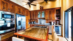 A modern kitchen with wooden cabinets, stainless steel appliances, and a central island. - Casa Pipilacha♛Impressive Ocean view♛ Infinity Edge Pool and ktcn (Tamarindo)