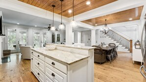 A spacious kitchen with a large island, wooden ceiling, and pendant lighting. - Luxury Vaycay! Private Pool, Billiards, Hot Tub, Putting Green - 2602 Hartnett (Isle of Palms)