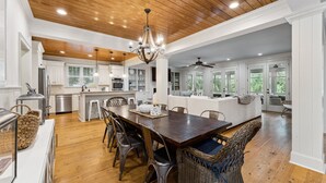 A spacious kitchen with wooden flooring, a central island, and modern appliances. - Luxury Vaycay! Private Pool, Billiards, Hot Tub, Putting Green - 2602 Hartnett (Isle of Palms)