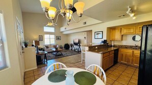 A spacious living area with a dining table, kitchen, and a chandelier. - Wild Card by Mesquite Vacation Rentals: Pet Friendly with Community Amenities and $510 in free daily activities (Mesquite)