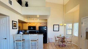 A spacious kitchen with wooden cabinets, a central island, and a dining area with chairs and a table. - Wild Card by Mesquite Vacation Rentals: Pet Friendly with Community Amenities and $510 in free daily activities (Mesquite)