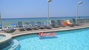 Ein Pool mit Liegestühlen und Sonnenschirmen, ein Whirlpool sowie ein Blick auf den Ozean.