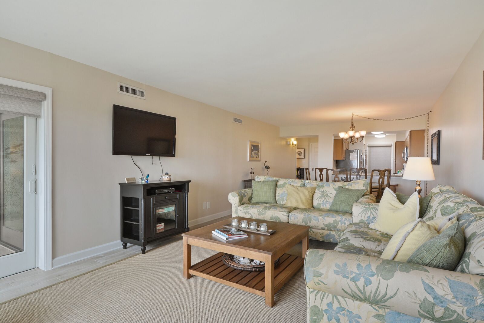 A living room with a sofa, a coffee table, a TV, and a fireplace.