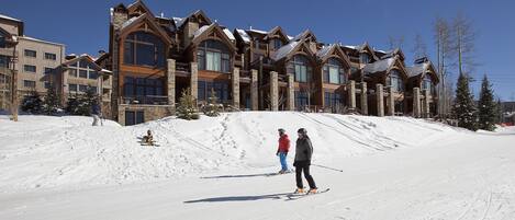 A ski resort with a large lodge featuring multiple stories and large windows.