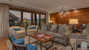 Una sala de estar moderna con un conjunto de sofá, una mesa de centro y un comedor con lámpara y mesa.