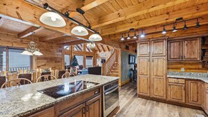 A spacious kitchen with granite countertops, wooden cabinets, and a central island. - Cabin w/Amazing Views, Large Game Room, Hot Tub (Sevierville)