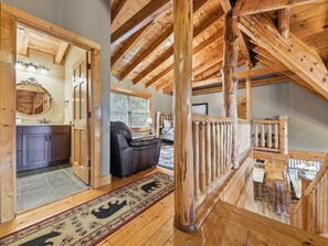 A wooden interior with a kitchen, a seating area, and a staircase. - Cabin w/Amazing Views, Large Game Room, Hot Tub (Sevierville)