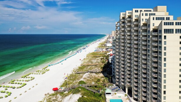 A beachfront hotel with a pool, beach access, and high-rise buildings.