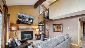 A modern living room with a fireplace, a sofa, a coffee table, and a staircase. - 4 O'Clock A16: Ski-In Condo, Gas Fireplace, 1 Block to Snowflake Lift. (Breckenridge)
