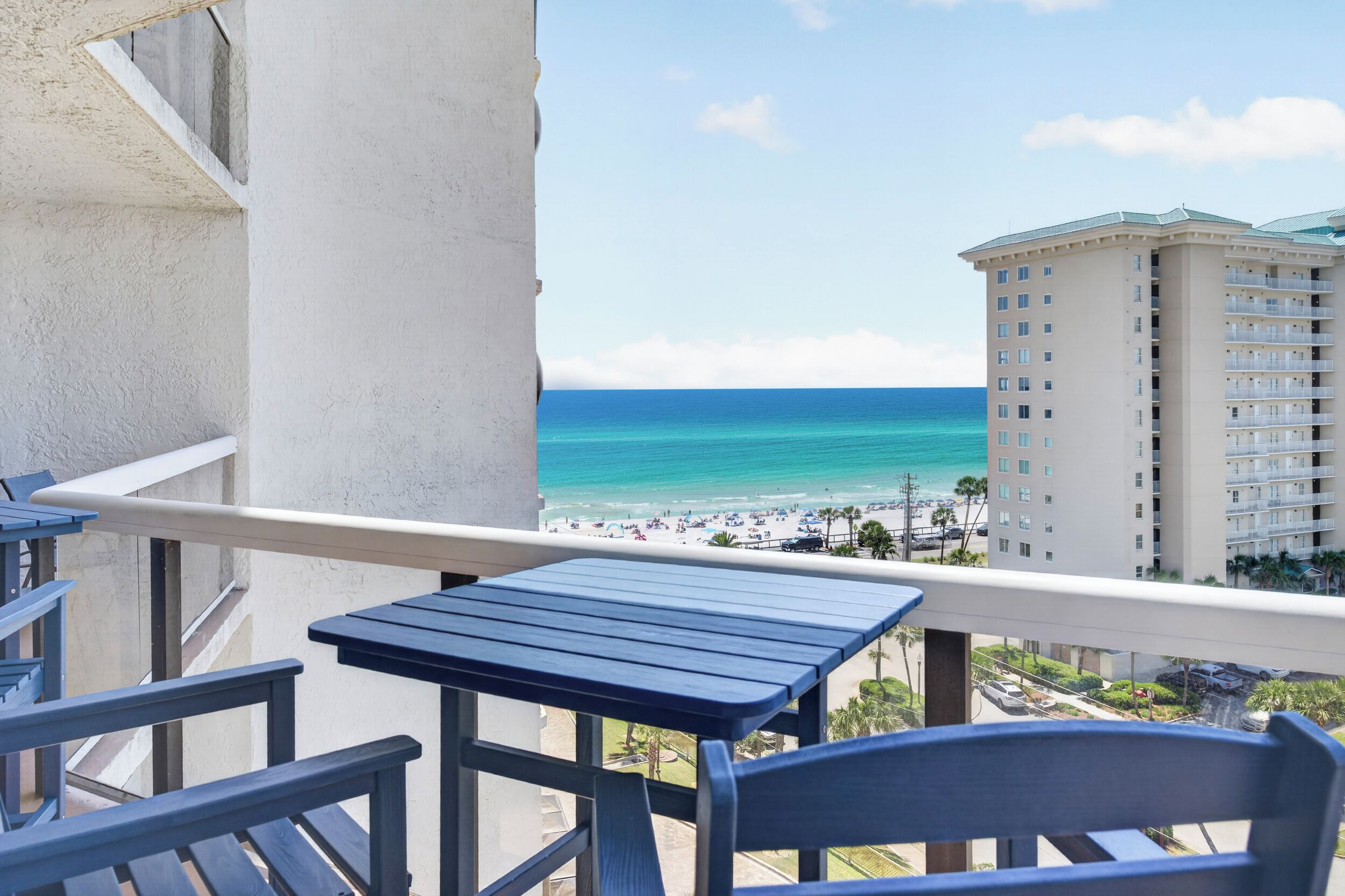 Un balcon avec vue sur la plage et un bâtiment d’hôtel.