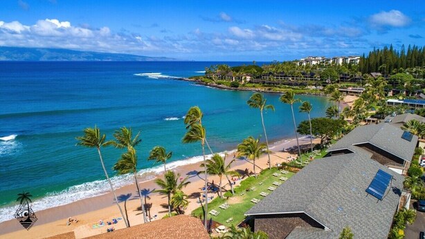 Un hôtel situé sur la côte, avec vue sur la plage, comprenant plusieurs chambres et un espace piscine.