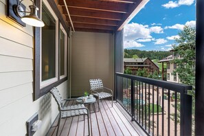 Enjoy a peaceful retreat with a balcony offering a view of the surrounding neighborhood and a swimming pool.