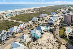 Uma área residencial à beira-mar, com casas, uma estrada e uma praia.