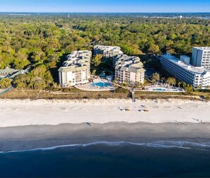 A coastal hotel complex with multiple buildings, a beachfront, and a swimming pool. - Oceanfront 2 bedroom villa in Villamare perfect for your next getaway! (Hilton Head Island)