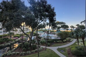 A resort with a swimming pool, lush landscaping, and a view of the ocean. - 3205 WCS - Beautiful OCEANVIEW luxury villa w/ Oceanfront Pool (Hilton Head Island)
