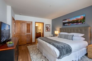 A bedroom with a large bed, a television, wooden wardrobe, and a painting on the wall. - ☀ Sunny Base Area Condo | Zephyr Mountain Lodge 1303 | Convenient Location | Direct Slope Views! (Winter Park)