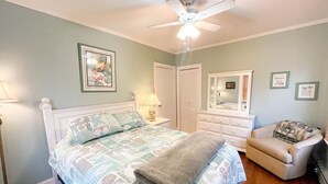 A bedroom with a bed, a nightstand, a dresser, a chair, a ceiling fan, and framed pictures on the wall. - Piece of Paradise-Pet Friendly-Walk to restaurants&shopping. (Cape May)