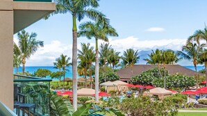 Ein Resort mit Poolbereich, Palmen und Blick aufs Meer.