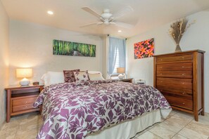 A bedroom with a bed, nightstands, a dresser, a ceiling fan, and wall art. - Maui Vista #2-423 Close to Kamaole Beach and Pickleball Courts! Pool, Wifi (Kihei)