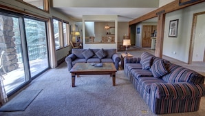 A spacious living room with a large window, a fireplace, and a dining area. - Spacious Townhome Mountain View & Private Hot Tub (Keystone)