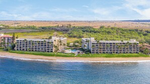 Un hôtel situé sur la côte, composé de plusieurs bâtiments, doté d’une piscine et offrant une vue sur la plage.