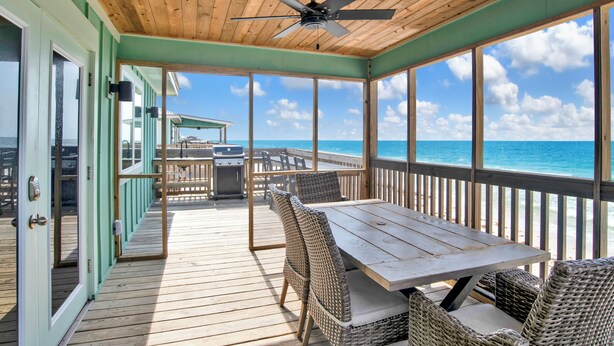 A covered outdoor deck with a table and chairs, overlooking the ocean. - Gulf Front | Pet Friendly | Spacious Porch (Gulf Shores)
